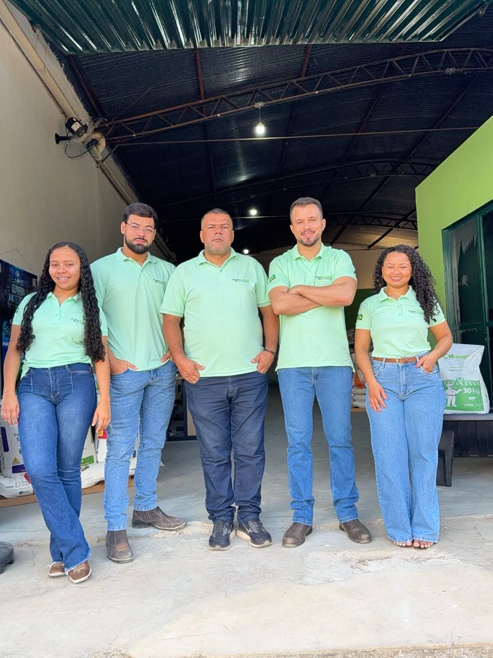Equipe da Agronordeste de camisa polo verde na entrada da loja